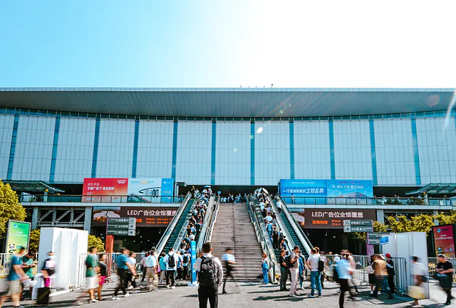 Compradores con acreditación entran al centro de exposiciones de Shanghái durante una feria industrial internacional.